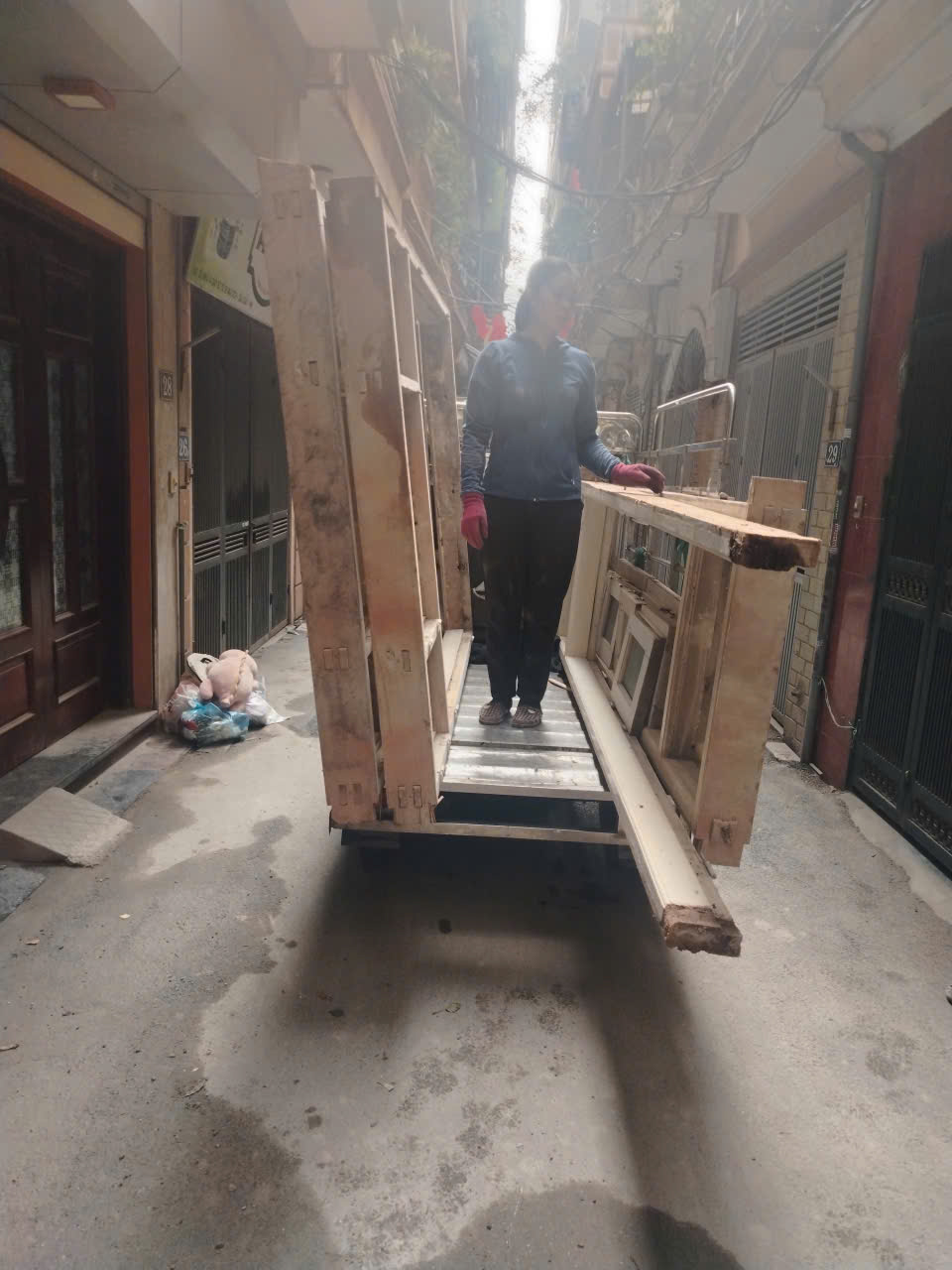 Xe ba gác chở đồ gỗ trong ngõ nhỏ