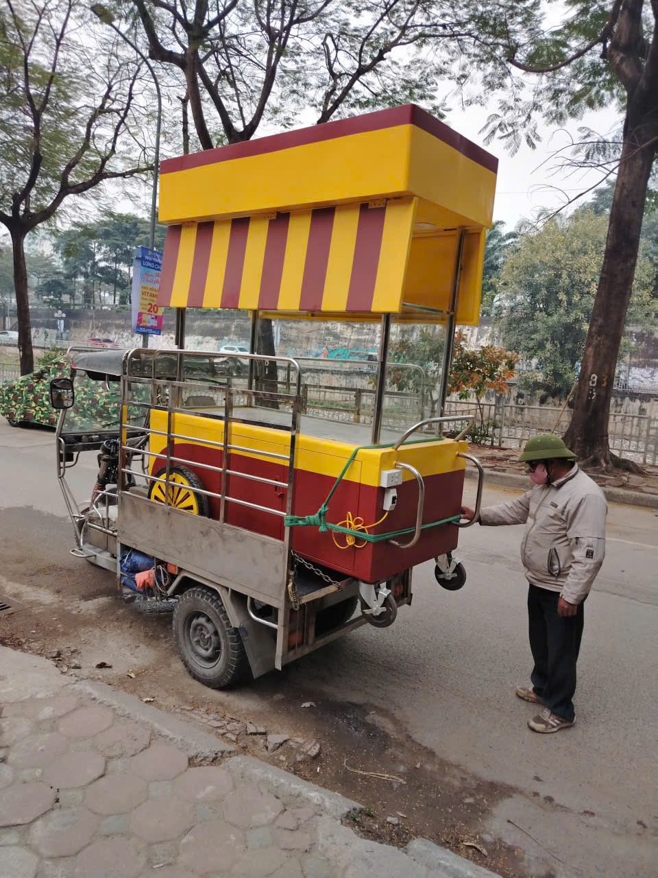 Xe ba gác chở quầy bán hàng màu vàng đỏ